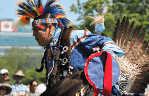 indigenous man wearing blue, yellow, and redceremonial wear