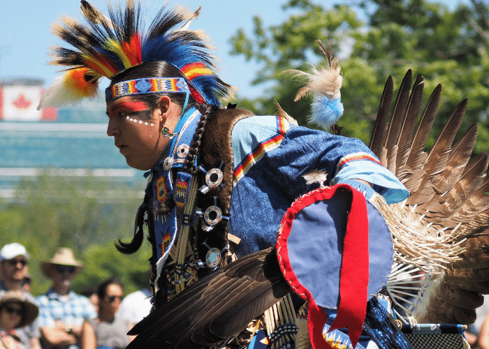 indigenous man wearing blue, yellow, and redceremonial wear