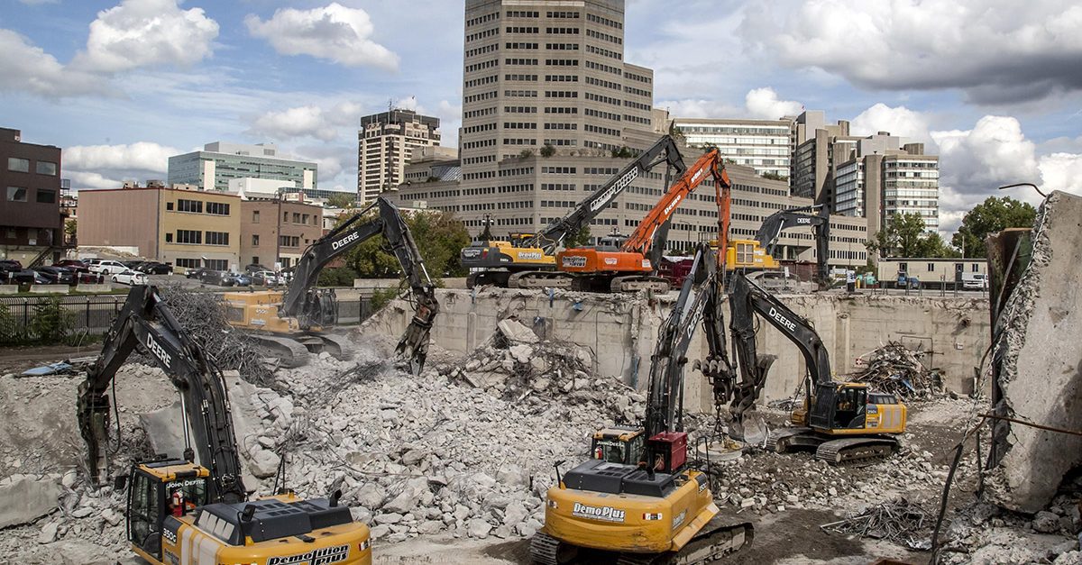 Demolition machines at a job site taking down concrete